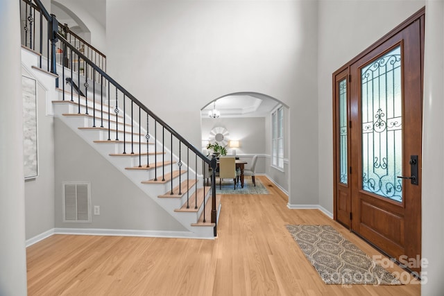 263 Fernbrook Dr, Mooresville, NC 28117 - entryway featuring wood finished floors, arched walkways, stairs, baseboards, and a high ceiling