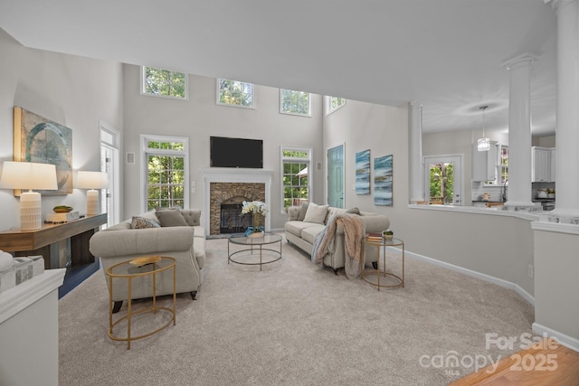263 Fernbrook Dr, Mooresville, NC 28117 - living area featuring decorative columns, a stone fireplace, baseboards, and carpet floors