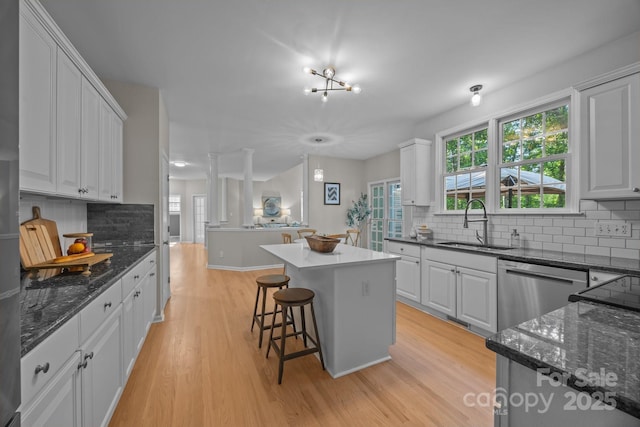 263 Fernbrook Dr, Mooresville, NC 28117 - kitchen featuring a sink, dishwasher, light wood-type flooring, backsplash, and white cabinetry
