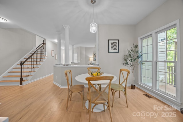 263 Fernbrook Dr, Mooresville, NC 28117 - dining room featuring light wood-style floors, stairs, baseboards, and decorative columns