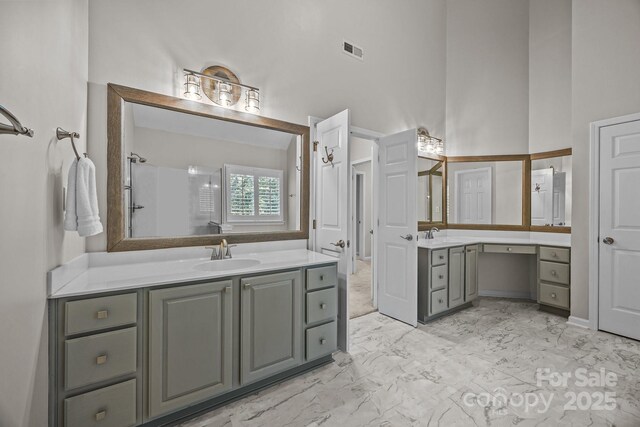 263 Fernbrook Dr, Mooresville, NC 28117 - full bathroom featuring two vanities, marble look tiles, a towering ceiling, and a shower