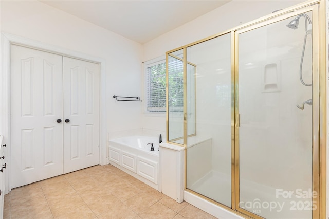 full bathroom featuring a shower stall, a garden tub, and tile patterned floors