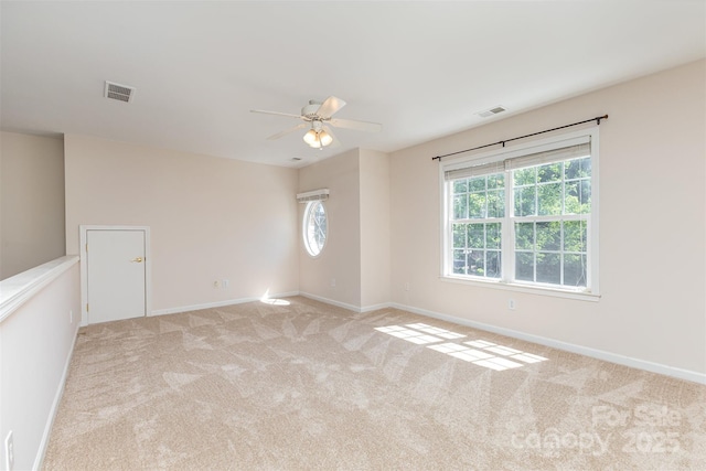 unfurnished room with ceiling fan, baseboards, and light colored carpet