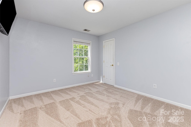 spare room featuring carpet flooring and baseboards