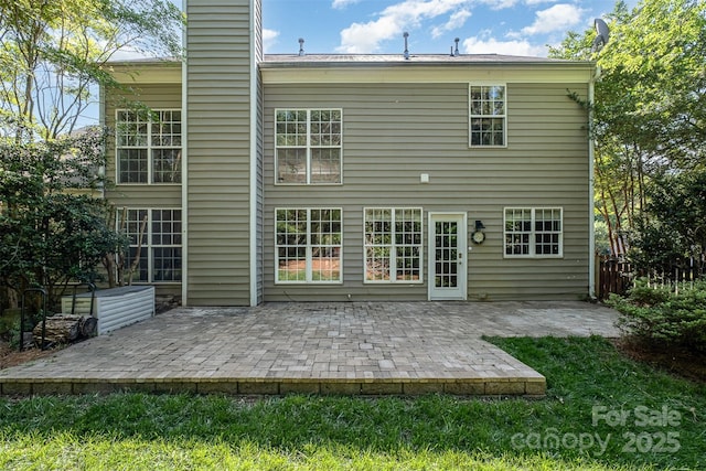 rear view of property with a patio area, a chimney, and fence