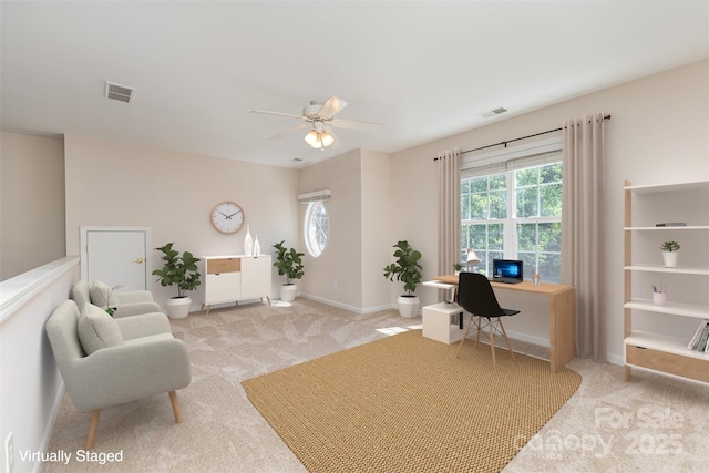 living room featuring light carpet, a desk, ceiling fan, and healthy amount of natural light