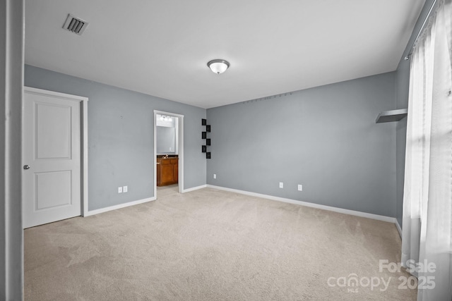 unfurnished bedroom with light colored carpet, baseboards, ensuite bath, and visible vents