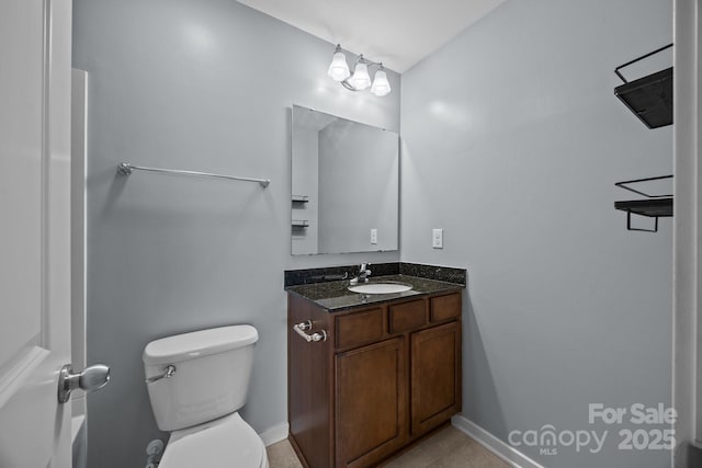 bathroom featuring baseboards, vanity, tile patterned floors, and toilet