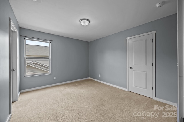 empty room with baseboards and carpet