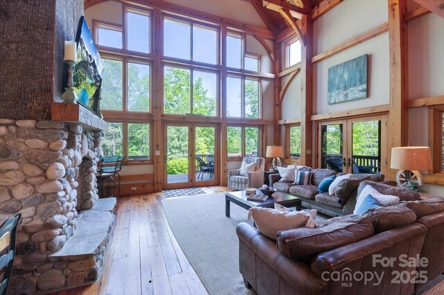 54 Cottage Grove Dr, Nebo, NC 28761 - living room featuring french doors, a towering ceiling, a stone fireplace, and hardwood / wood-style floors