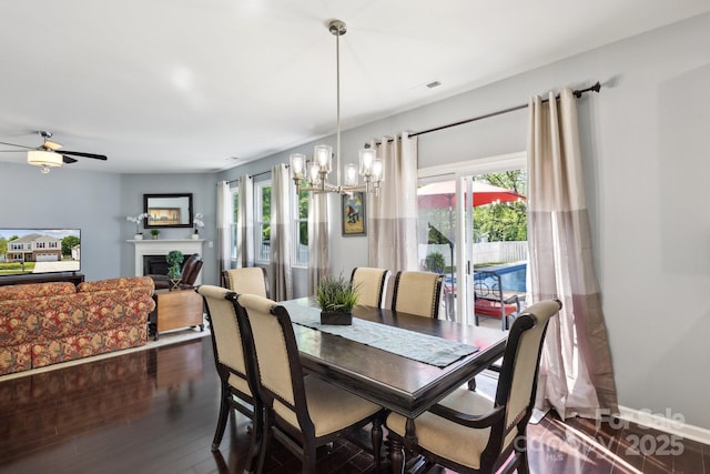 221 Sycamore Creek Rd, Fort Mill, SC 29708 - dining room featuring ceiling fan with notable chandelier, a fireplace, visible vents, baseboards, and dark wood-style floors