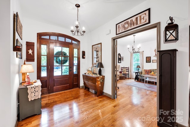 entryway with an inviting chandelier and light wood-style flooring