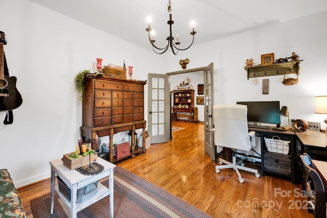 office space with an inviting chandelier, wood finished floors, french doors, and baseboards