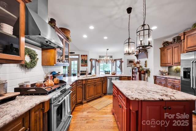 kitchen with tasteful backsplash, light wood-style flooring, appliances with stainless steel finishes, exhaust hood, and recessed lighting