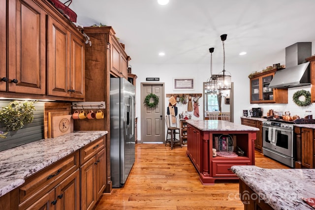 kitchen with light wood-style flooring, wall chimney exhaust hood, open shelves, and stainless steel appliances