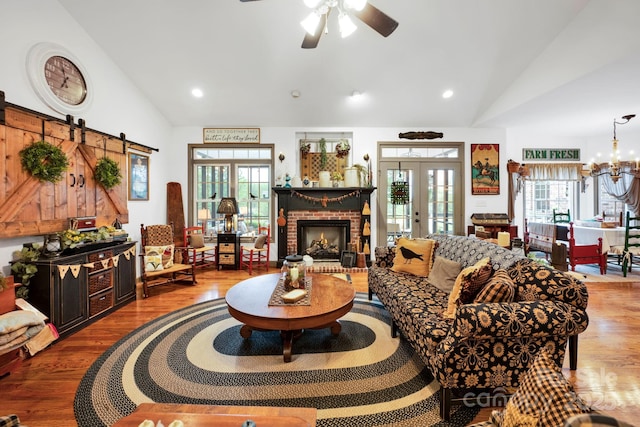 living area featuring wood finished floors, a healthy amount of sunlight, french doors, and vaulted ceiling