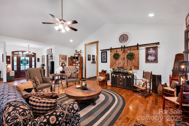 living area featuring recessed lighting, a barn door, a ceiling fan, vaulted ceiling, and wood finished floors