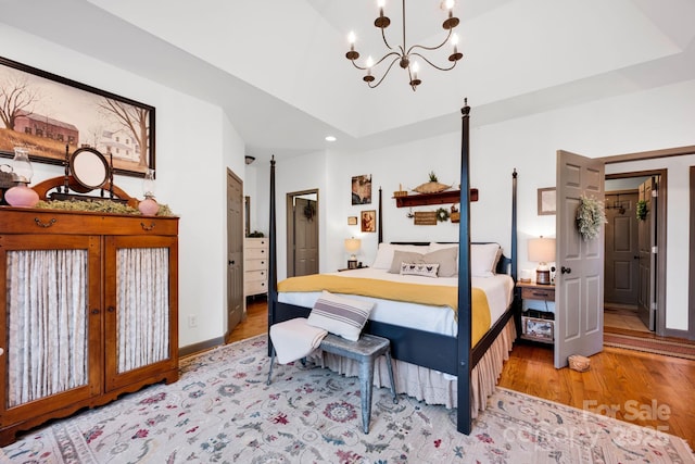 bedroom featuring an inviting chandelier, wood finished floors, recessed lighting, and baseboards
