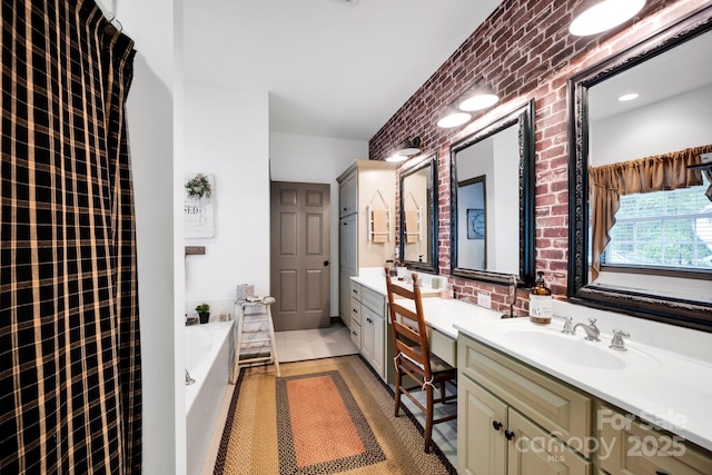 bathroom featuring a garden tub, tile patterned flooring, vanity, and brick wall