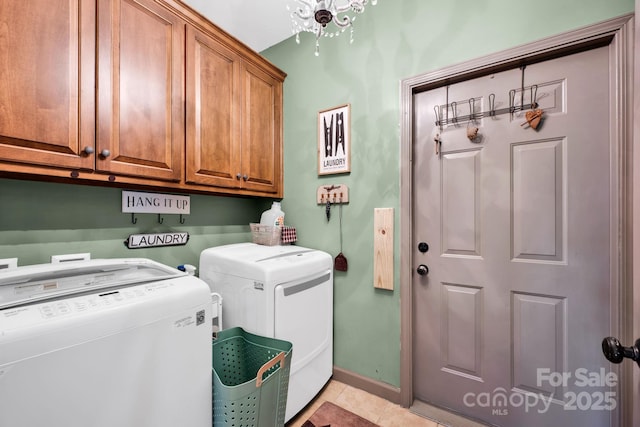 washroom with light tile patterned floors, washing machine and clothes dryer, cabinet space, and baseboards