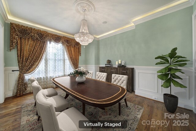dining room with a decorative wall, a wainscoted wall, a notable chandelier, and crown molding