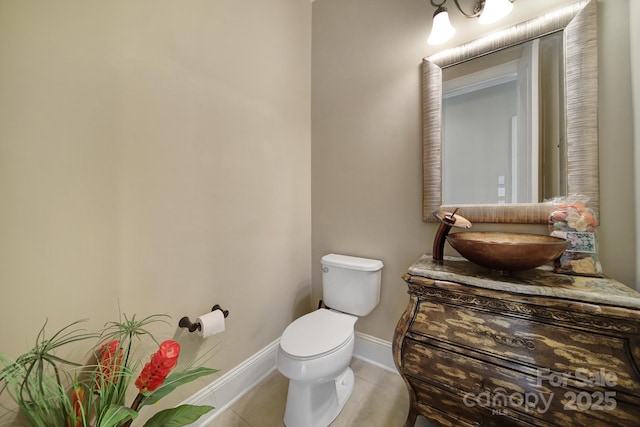 bathroom with baseboards, tile patterned flooring, vanity, and toilet