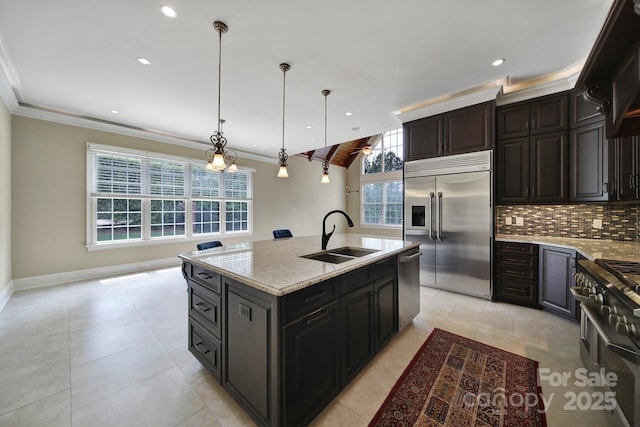 kitchen featuring tasteful backsplash, crown molding, premium appliances, and a sink