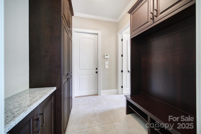 mudroom featuring crown molding and light tile patterned floors