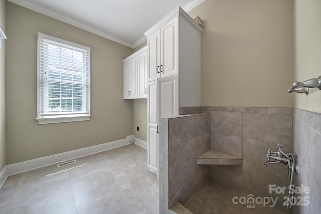 bathroom featuring baseboards, visible vents, tile patterned flooring, and crown molding