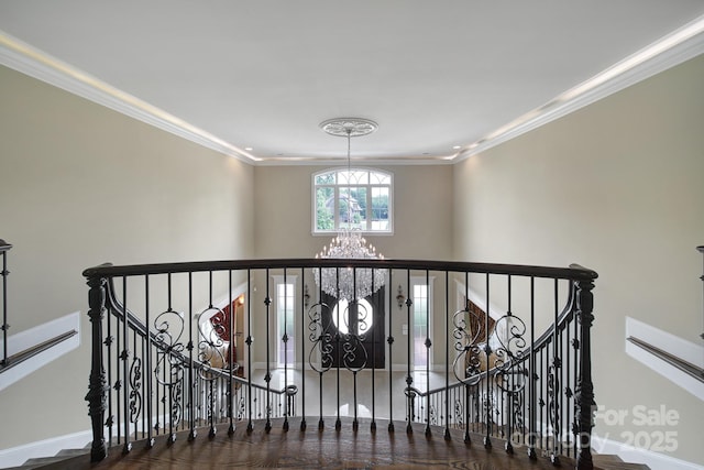 interior space with crown molding, a notable chandelier, and baseboards