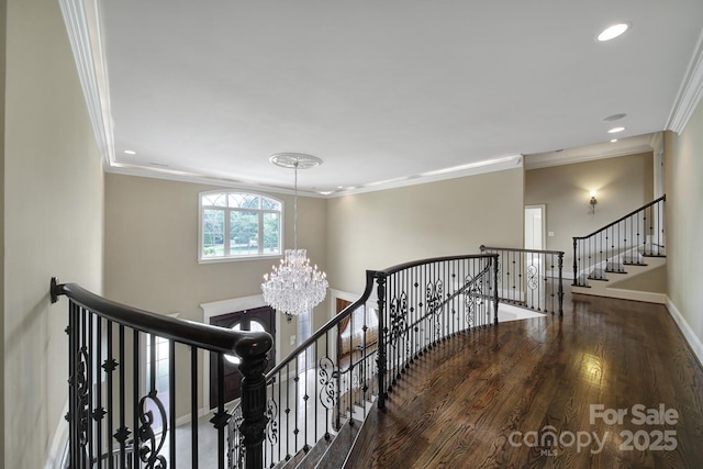 stairs featuring baseboards, recessed lighting, a notable chandelier, wood finished floors, and ornamental molding