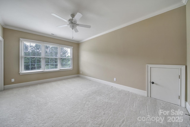 empty room featuring ceiling fan, baseboards, ornamental molding, and carpet flooring