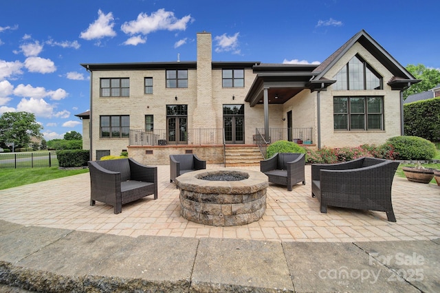view of patio featuring an outdoor living space with a fire pit and fence