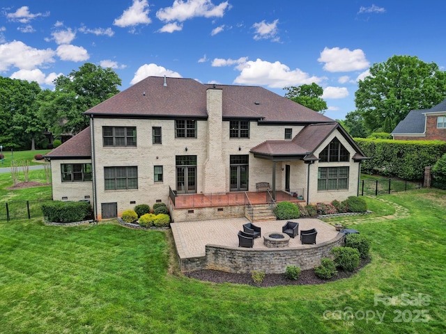 back of house with a fenced backyard, a yard, a patio, and an outdoor fire pit