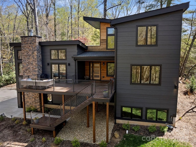 146 Timber Creek Rd, Hendersonville, NC 28739 - back of property featuring a deck, stone siding, and stairs