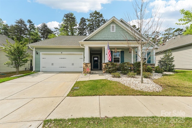 craftsman-style house featuring a front lawn, driveway, covered porch, and a garage