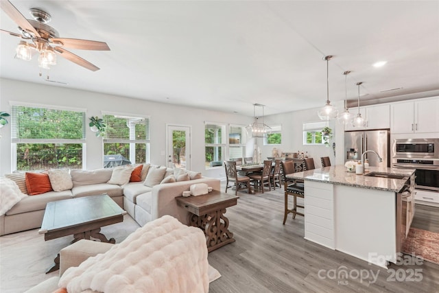 living room with recessed lighting, light wood-style floors, and ceiling fan