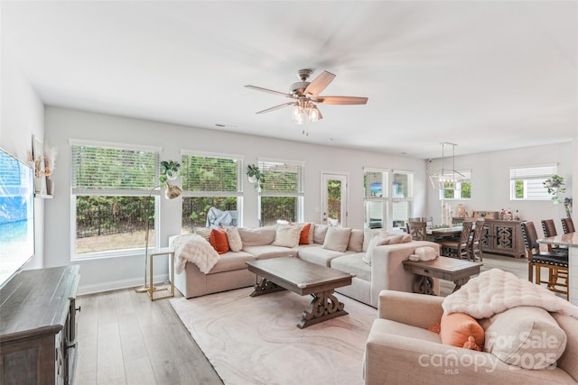 living room featuring ceiling fan, baseboards, visible vents, and light wood-style flooring