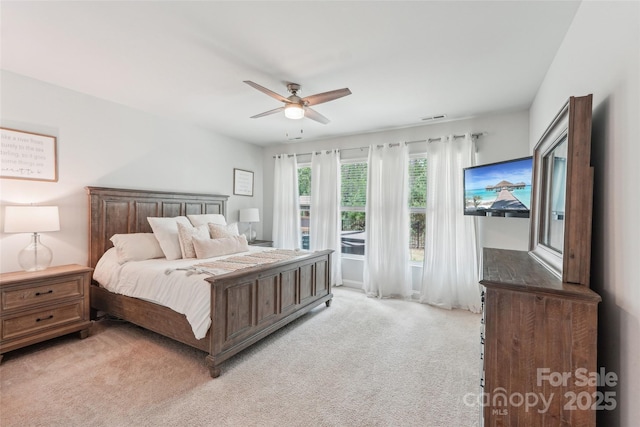 bedroom with light colored carpet, a ceiling fan, and visible vents