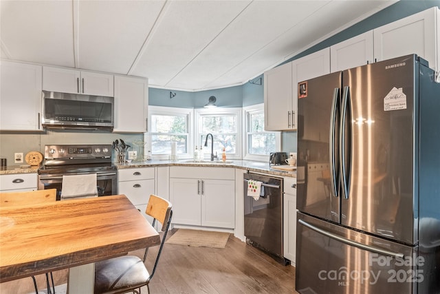 6778 Emerald Isle Dr, Sherrills Ford, NC 28673 - kitchen with stainless steel appliances, white cabinetry, wood finished floors, and light stone counters