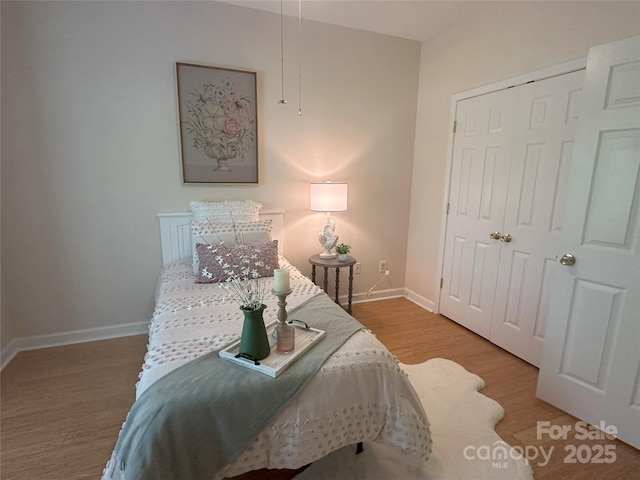 bedroom featuring baseboards, a closet, and wood finished floors