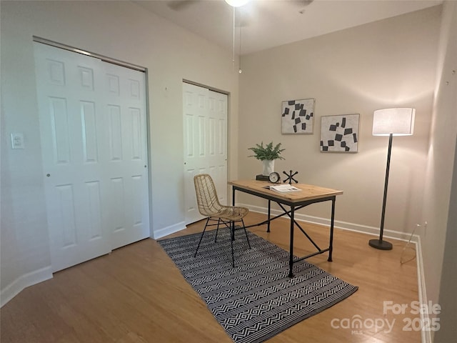 office featuring baseboards, ceiling fan, and wood finished floors