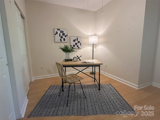 office space with baseboards and light wood-type flooring