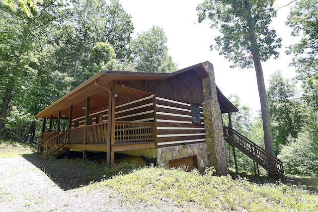 view of side of property with a chimney, a deck, and stairs