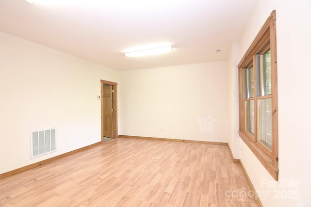 unfurnished room featuring baseboards, visible vents, and light wood-type flooring