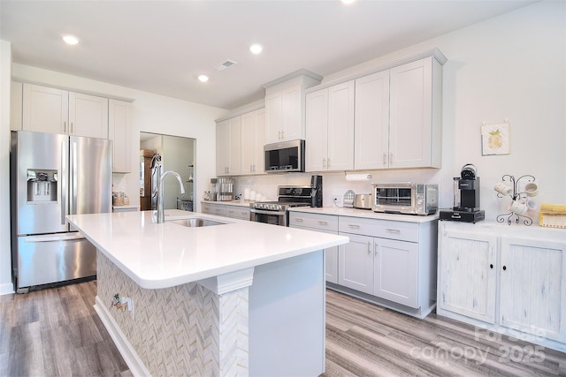 11616 Solstice Way, Huntersville, NC 28078 - kitchen with a kitchen island with sink, stainless steel appliances, light wood finished floors, and a sink