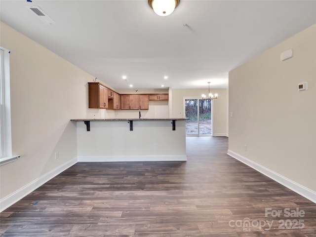 4149 River Run Cir, Hickory, NC 28602 - kitchen with a peninsula, an inviting chandelier, visible vents, and a kitchen breakfast bar