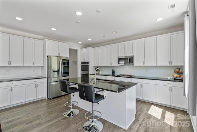 184 Tetcott St, Mooresville, NC 28115 - kitchen featuring a sink, visible vents, backsplash, dark countertops, and appliances with stainless steel finishes