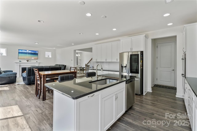 184 Tetcott St, Mooresville, NC 28115 - kitchen with a sink, dark wood-style flooring, open floor plan, white cabinetry, and appliances with stainless steel finishes