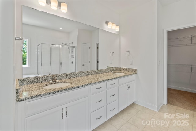 184 Tetcott St, Mooresville, NC 28115 - bathroom featuring a sink, double vanity, a stall shower, baseboards, and a spacious closet